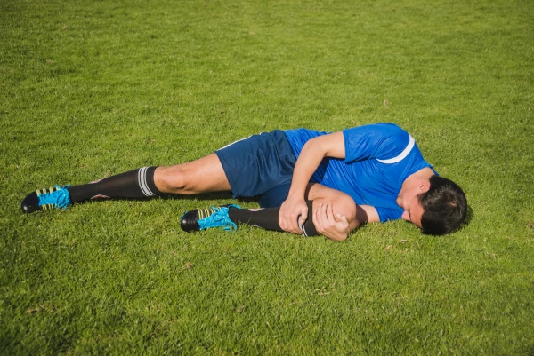 sports physiotherapy - Injured football player in pain