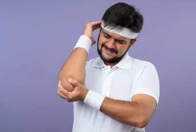 Golfer's Elbow - injured-young-sporty-man-wearing-headband-wristband-grabbed-aching-elbow